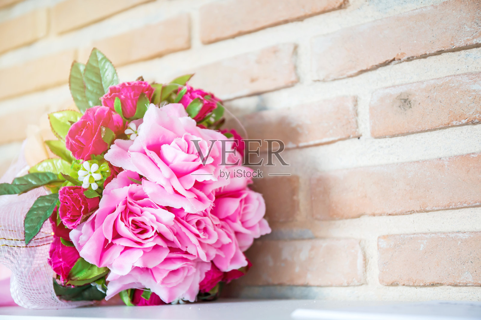 木桌上的花盆里装着人造花照片摄影图片