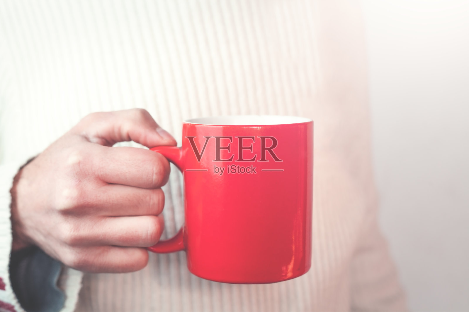 拿着红色咖啡杯的男人。照片摄影图片