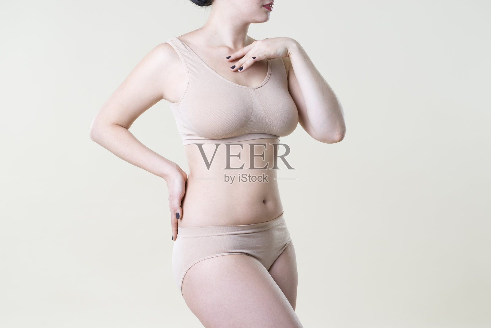 在工作室背景米色内衣的女人,完美的女性身体照片摄影图片