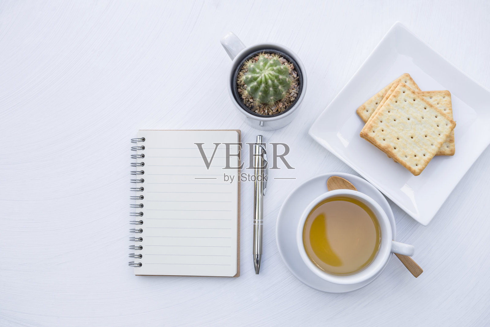 空白笔记本,热茶和饼干在白色的桌子背景照片摄影图片