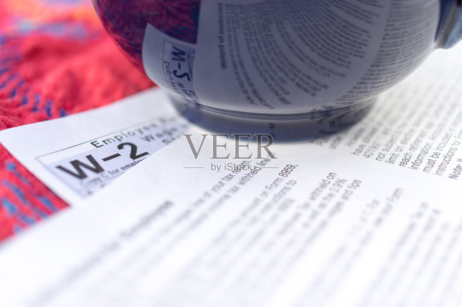 一杯咖啡放在收益表上,反映了收益表(W-2)照片摄影图片