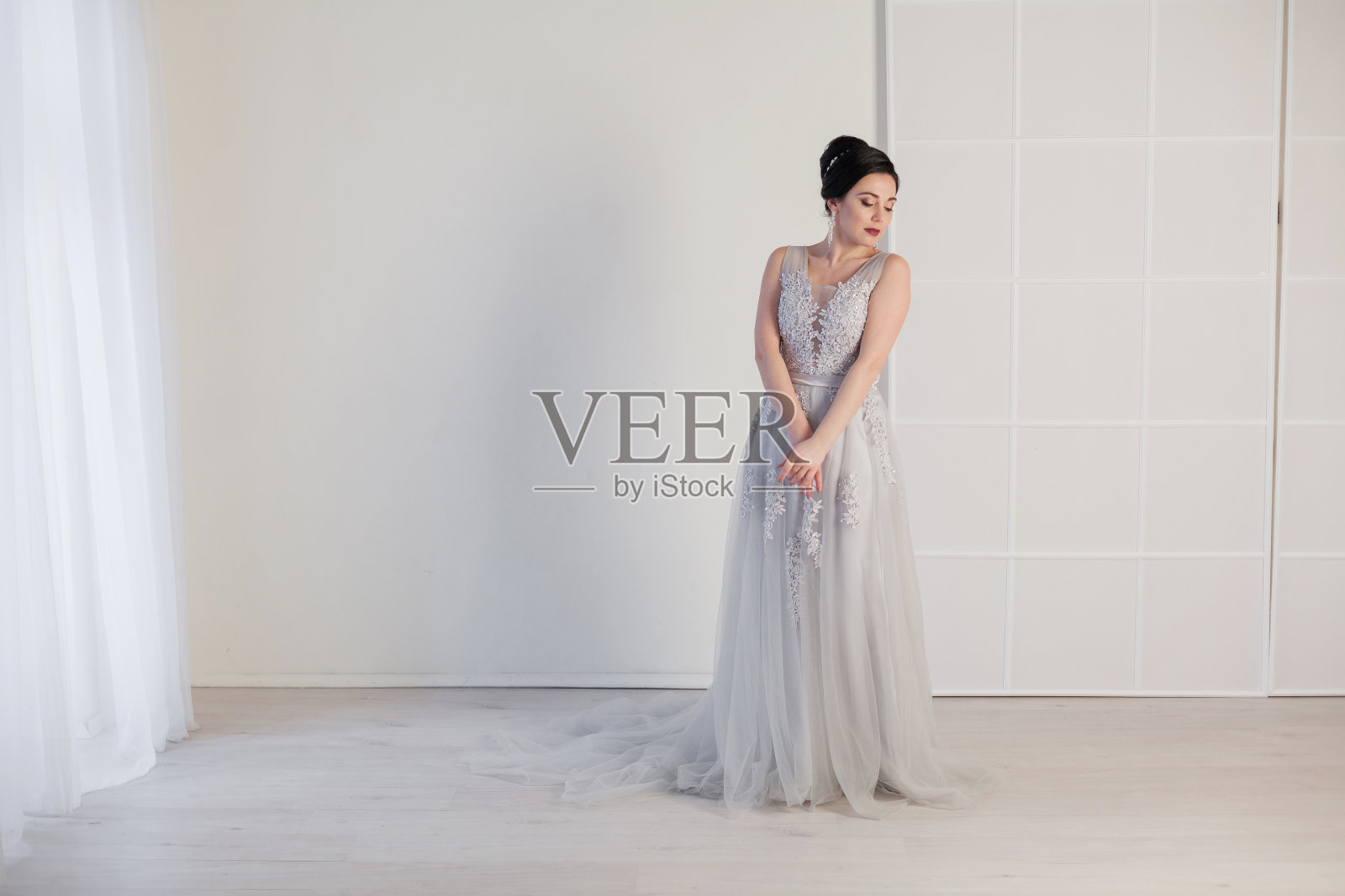 穿着婚纱的新娘在白色的房间里照片摄影图片