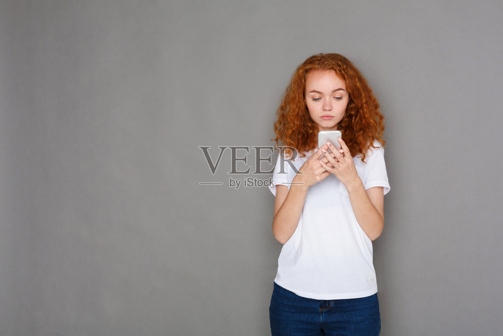 年轻女子用智能手机发短信,拍摄完毕照片摄影图片