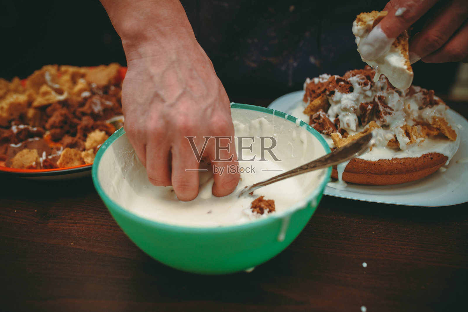 年轻厨师涂抹奶油蛋糕照片摄影图片