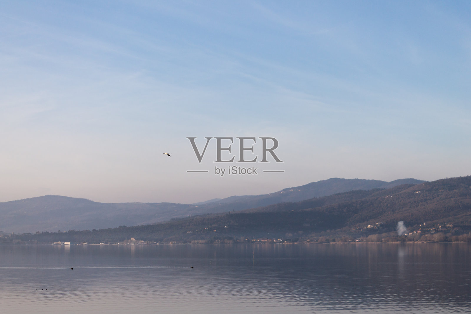 特拉西梅诺湖(意大利翁布里亚)美景,山丘和蓝天倒映在水中照片摄影图片