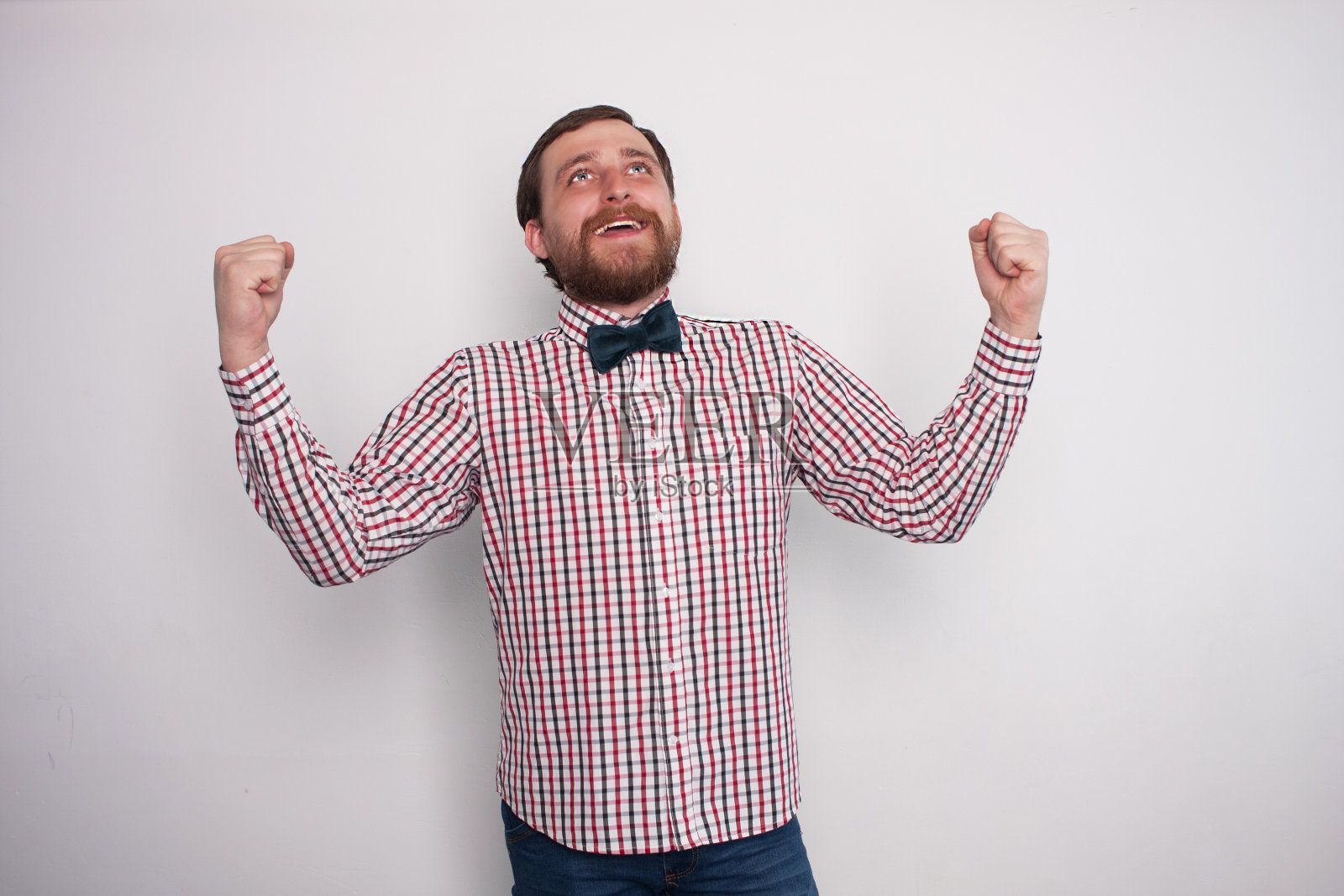 年轻的蓄着胡须的白人嬉皮士感觉胜利!他尖叫着举起他的拳头。照片摄影图片