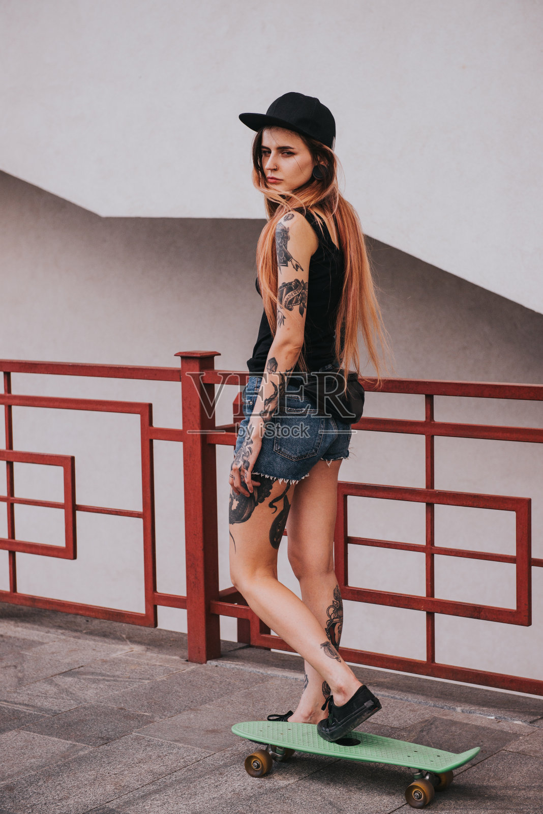 漂亮的纹身女孩与滑板照片摄影图片