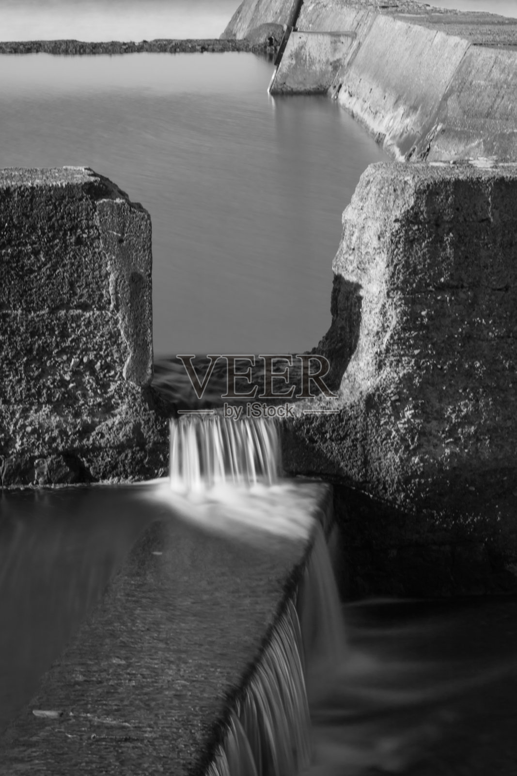 近景的潮汐池与海水与波浪的黑白照片摄影图片