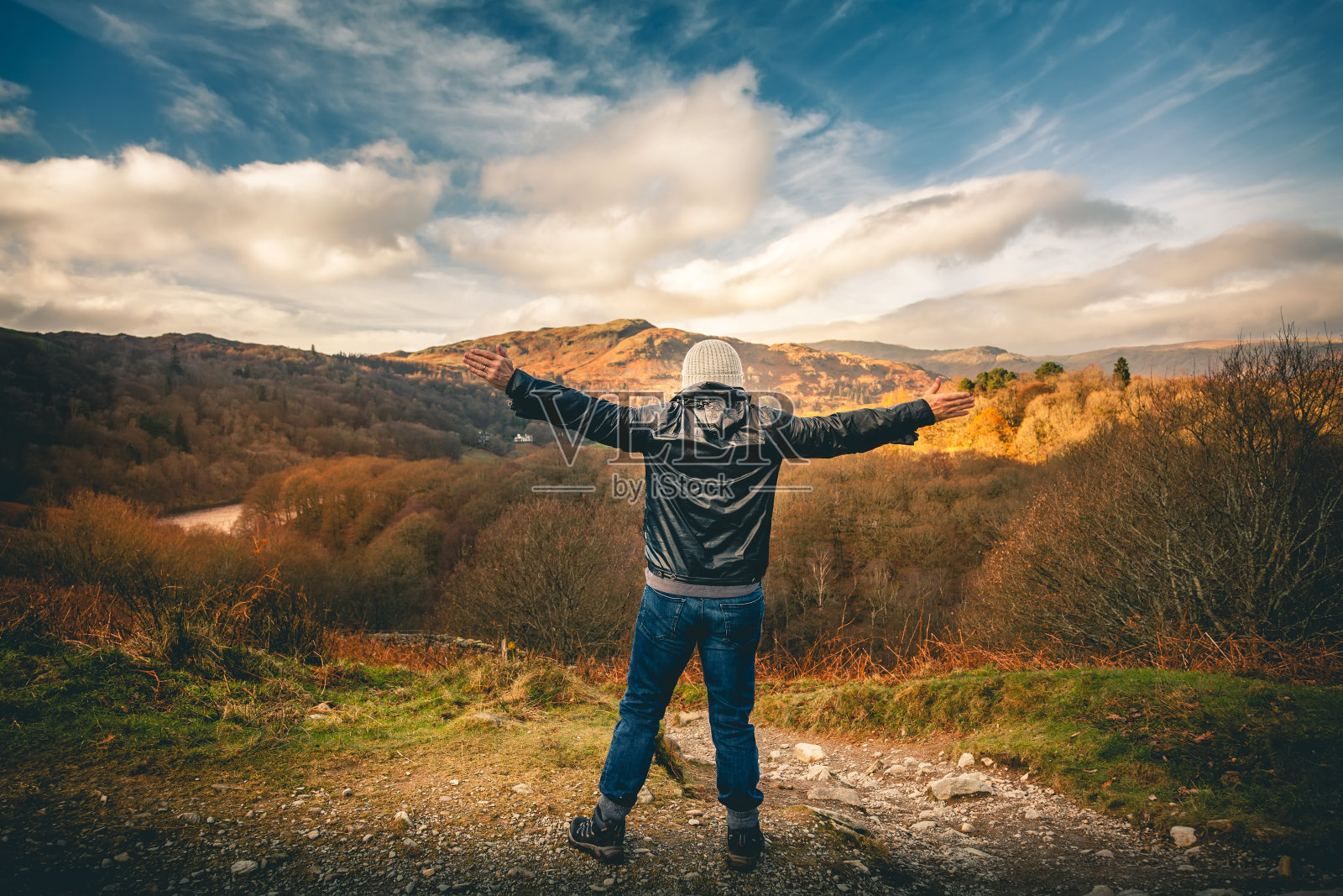 在山顶上伸开双臂的人照片摄影图片