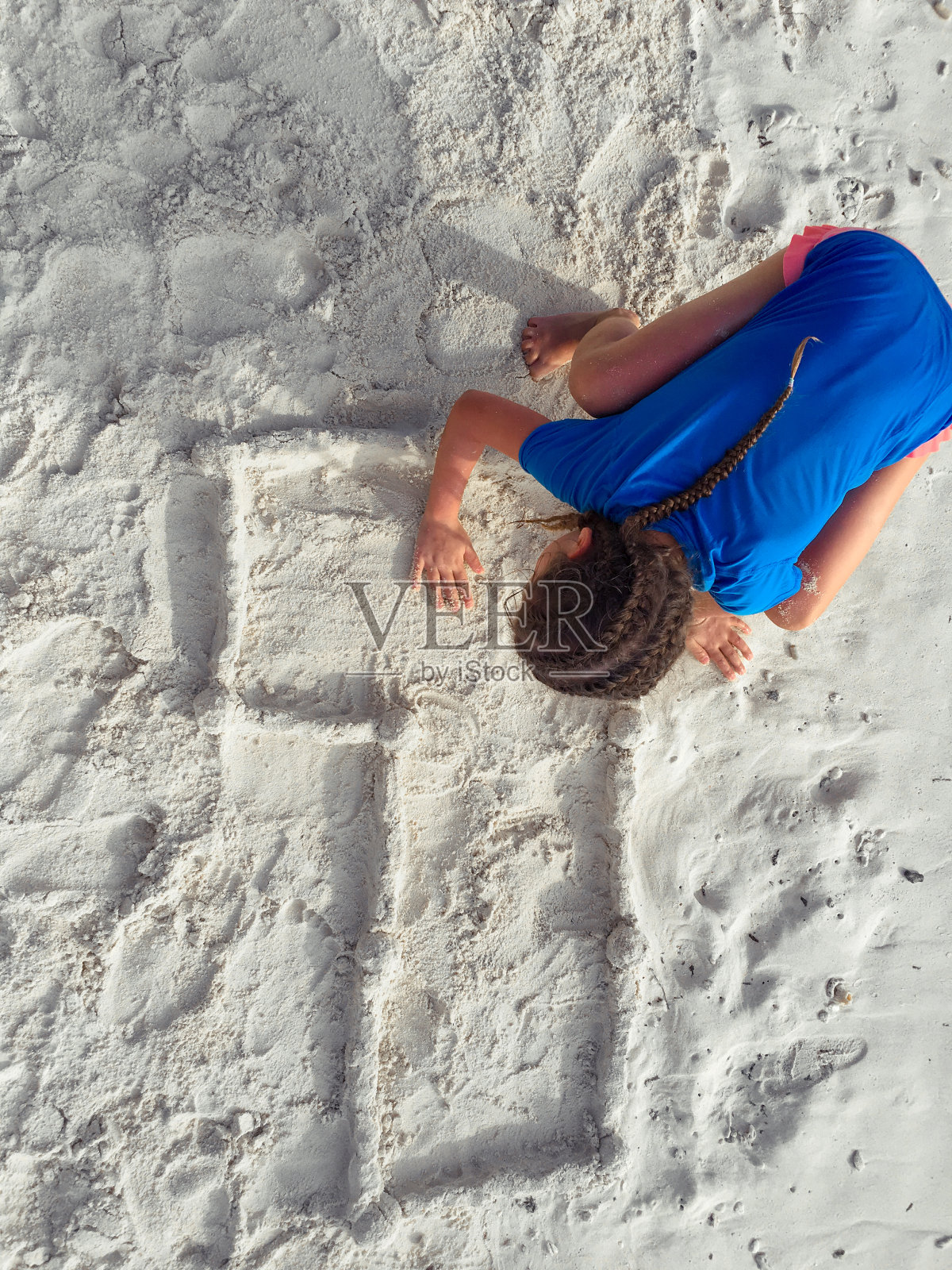 顽皮的小女孩在沙滩上用沙子做一号照片摄影图片