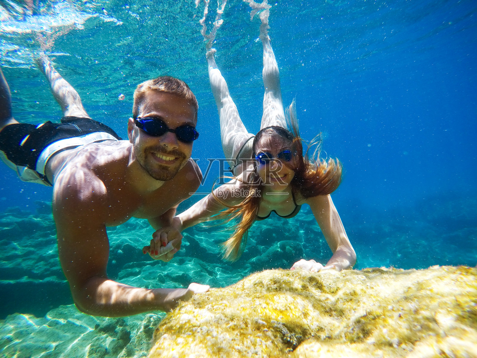 水下照片的年轻可爱浪漫的情侣探索和享受与目镜在异国情调的绿松石海附近的珊瑚礁,而手牵手。照片摄影图片