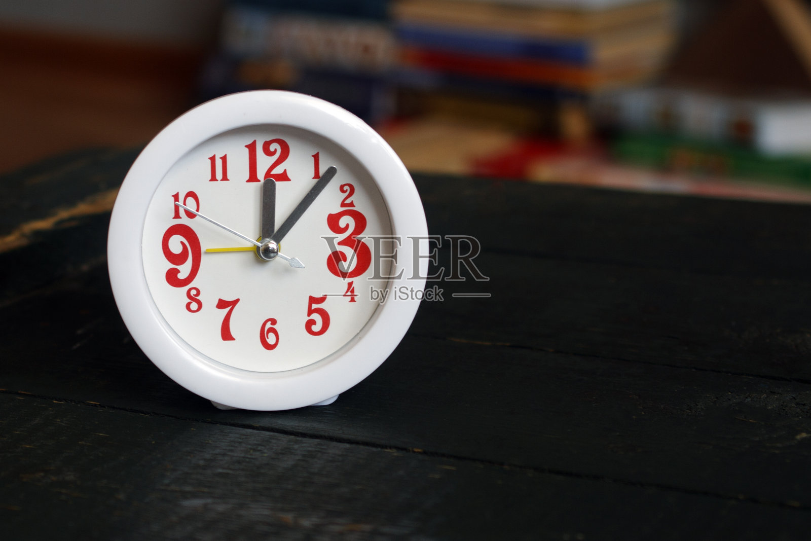 木制桌子上的红色数字的白色闹钟照片摄影图片