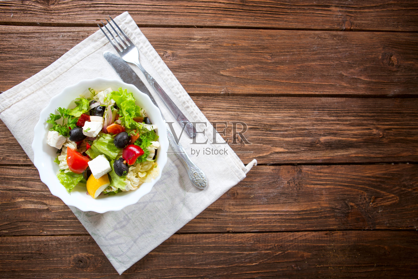 新鲜的希腊沙拉,配番茄、羊乳酪、橄榄放在木桌上照片摄影图片
