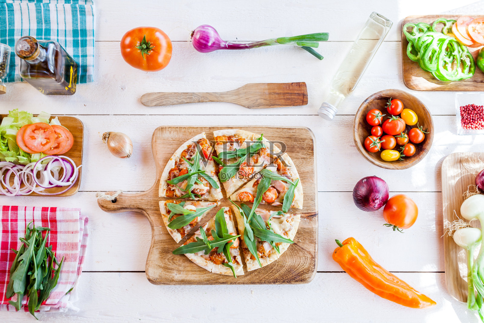 新鲜的自制传统意大利披萨配上奶酪、番茄和摇晃的沙拉,放在木桌上。披萨和食品概念墙纸。俯视图,平放照片摄影图片