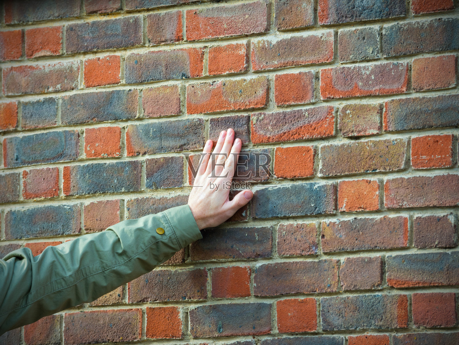 手放在砖墙上照片摄影图片