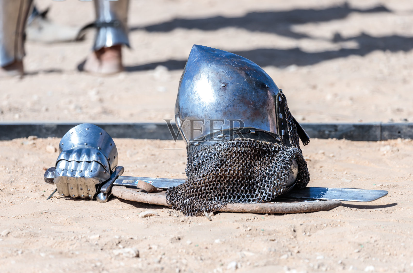 装备骑士-骑士节的参与者-盾牌、剑、头盔和手套躺在竞技场附近的地上照片摄影图片