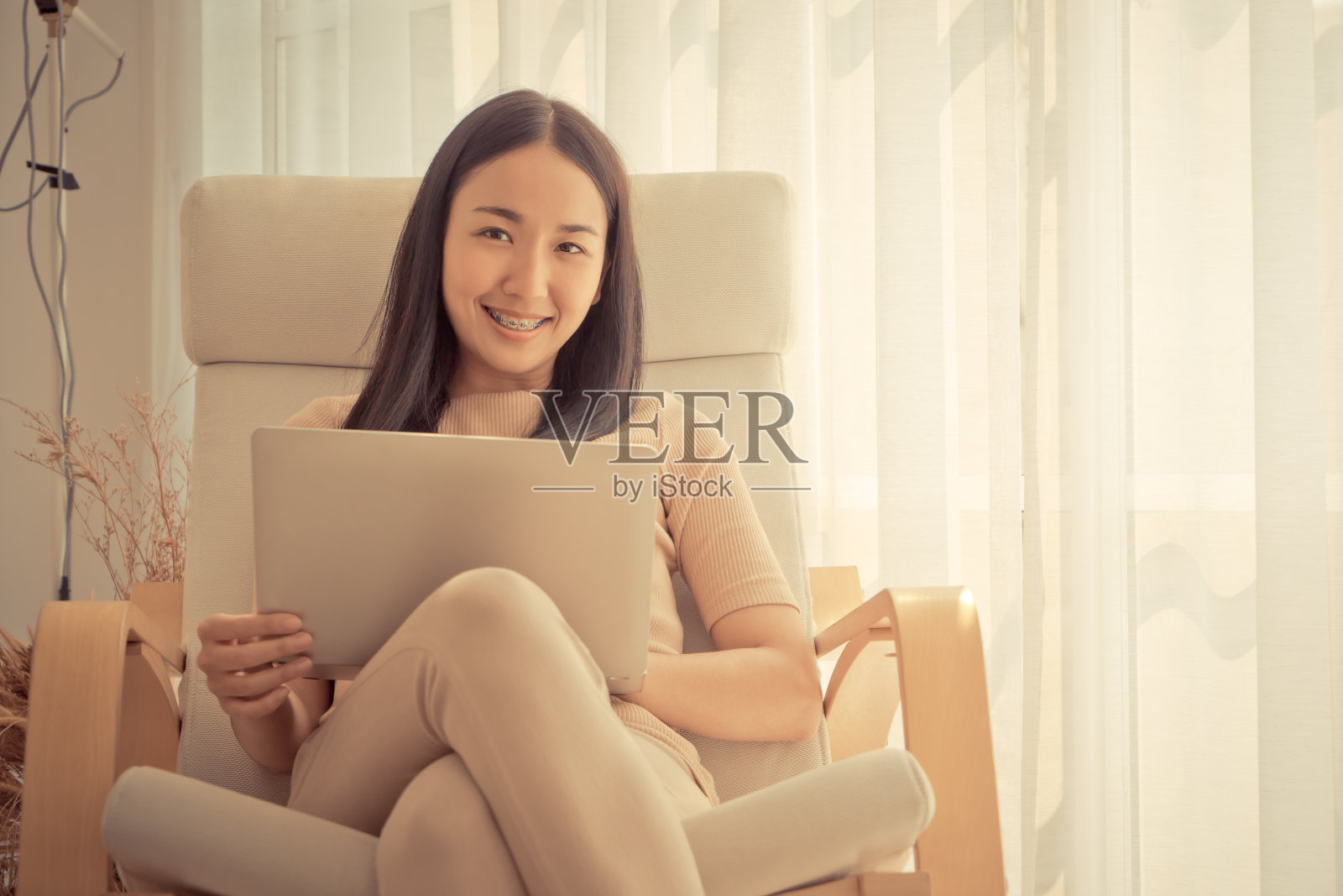 快乐的亚洲女人在沙发上使用笔记本电脑照片摄影图片