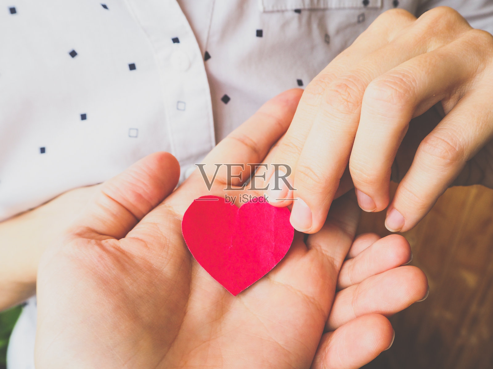 捐赠的心脏。他手里拿着大大小小的红心。照片摄影图片