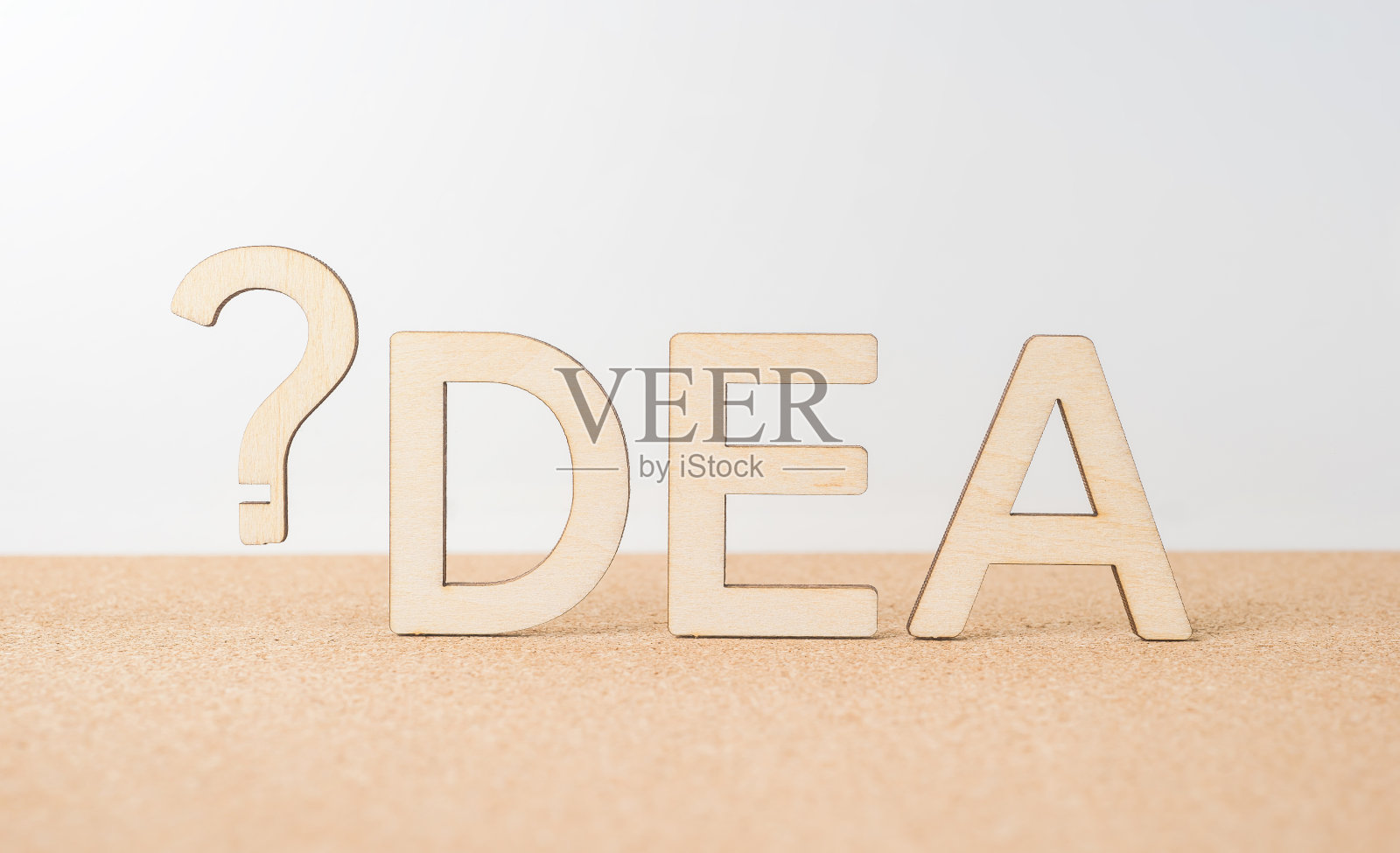 木制桌面上的“想法”字样和问号照片摄影图片