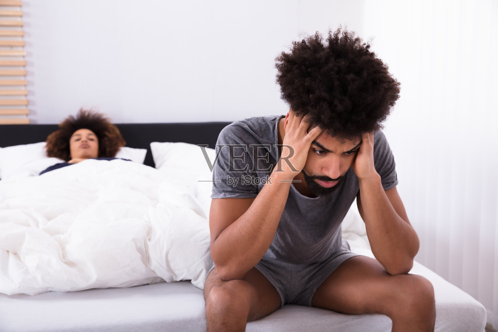 沮丧的男人坐在床上照片摄影图片
