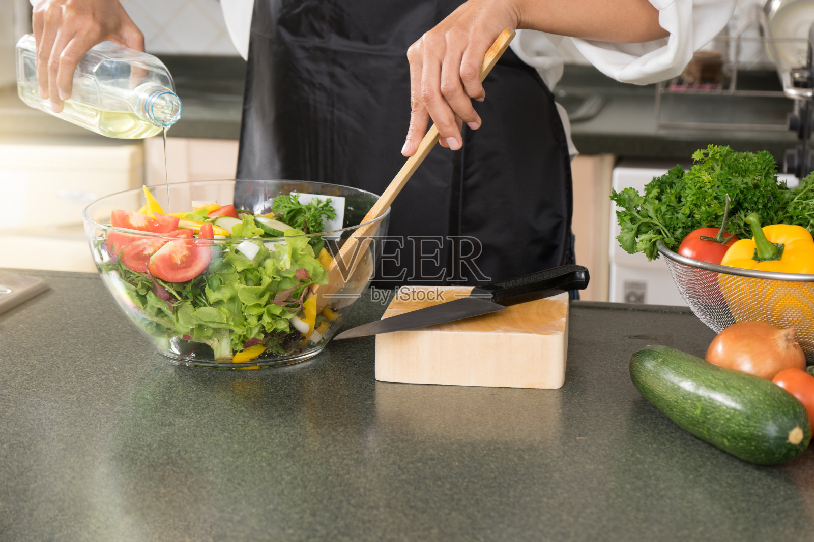 年轻的亚洲妇女在现代厨房做饭照片摄影图片