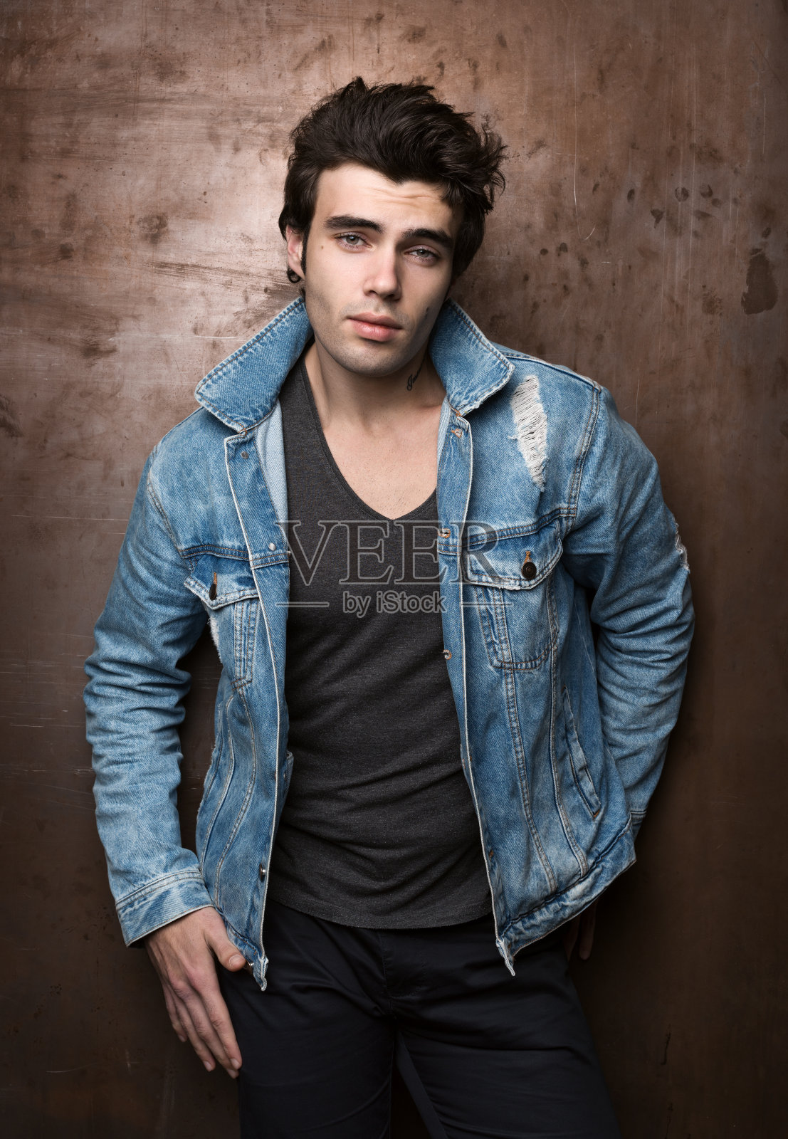 一个无忧无虑的年轻人的时尚肖像穿着休闲的金属墙照片摄影图片