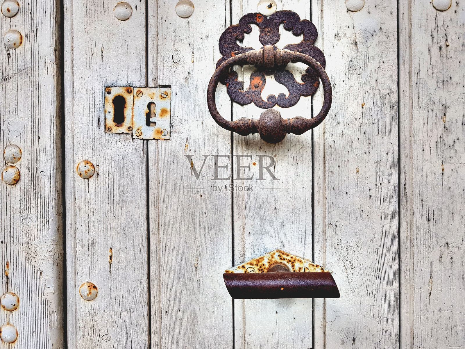 一扇带有生锈铁器的旧木门。照片摄影图片