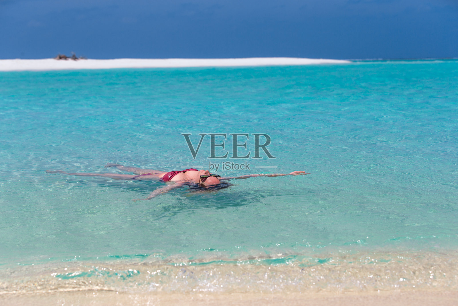 在热带岛屿上漂浮的年轻女子照片摄影图片