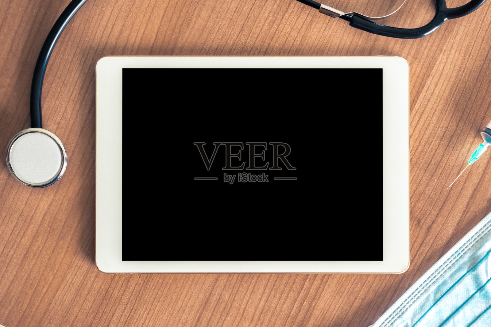 医用桌子上的数字平板,配有听诊器、注射器和卫生口罩。空的空间或空白的信息或你的文本照片摄影图片