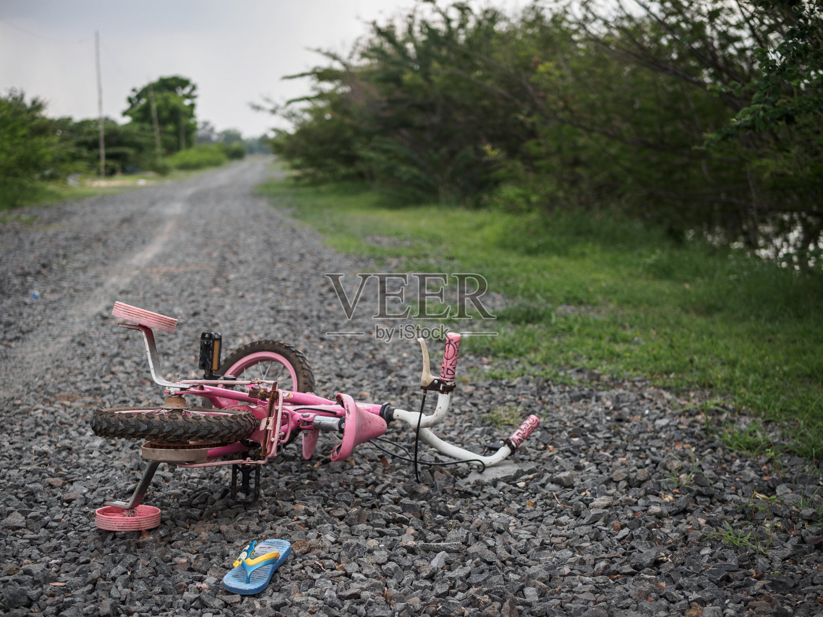 孩子们的自行车和鞋在石头路上。失踪儿童的概念。国际失踪儿童日。照片摄影图片