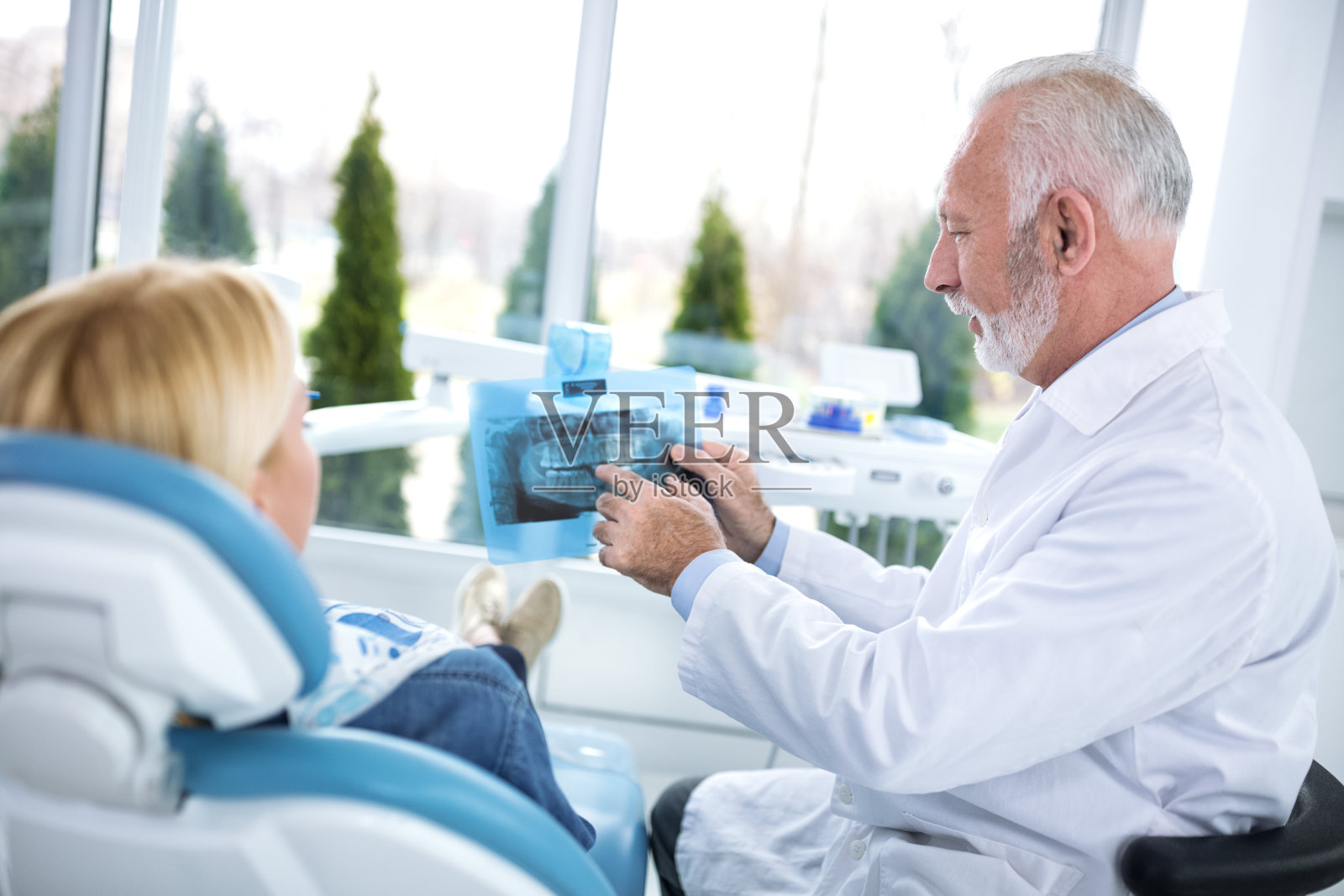 牙科医生和病人在看牙齿的x光照片摄影图片