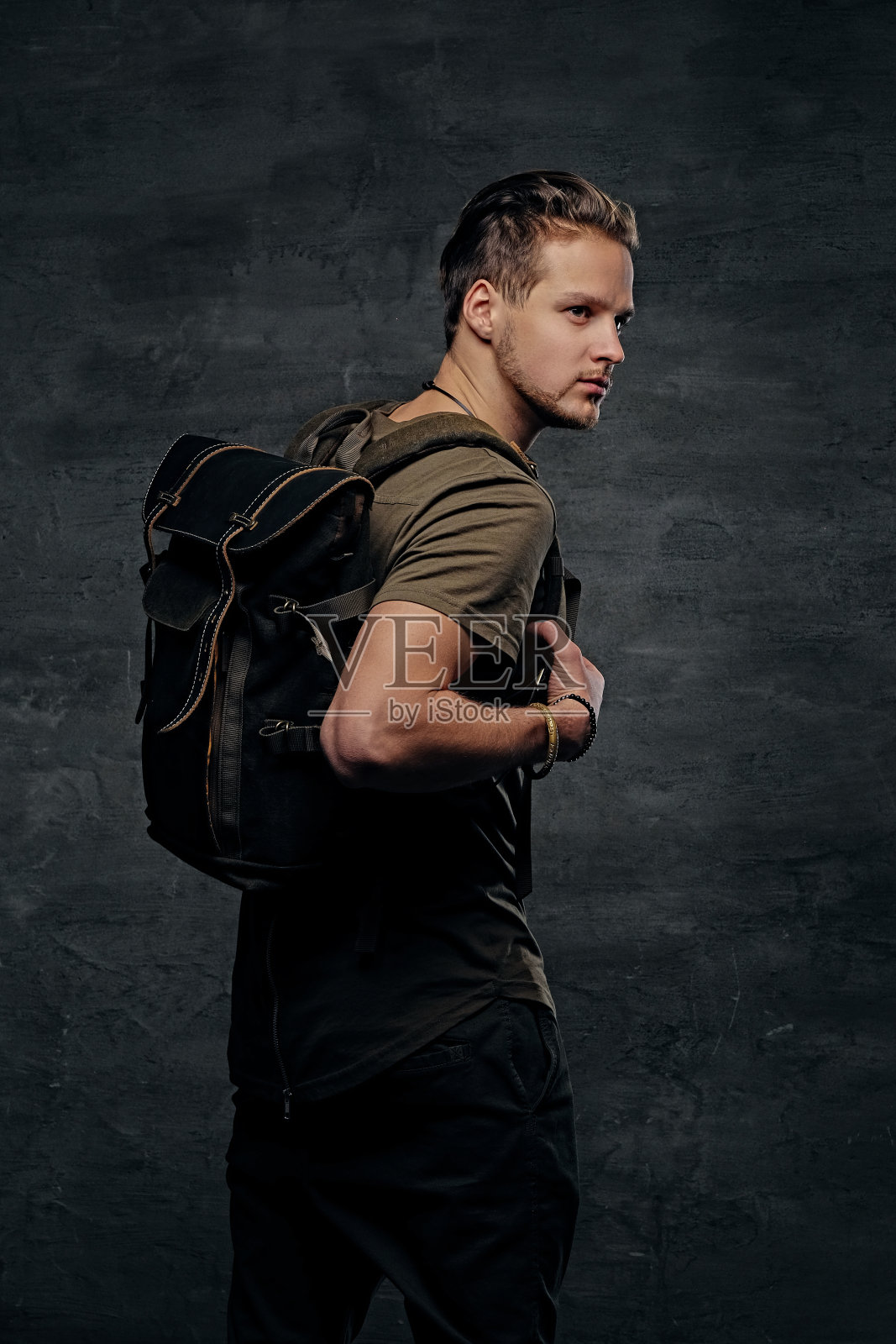 背包客身着迷彩绿色t恤,手臂上有纹身。照片摄影图片