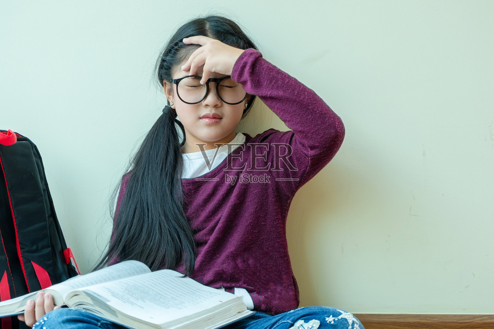 可爱的女孩坐在房间里感觉又累又头痛,孩子的观念,教育观念照片摄影图片