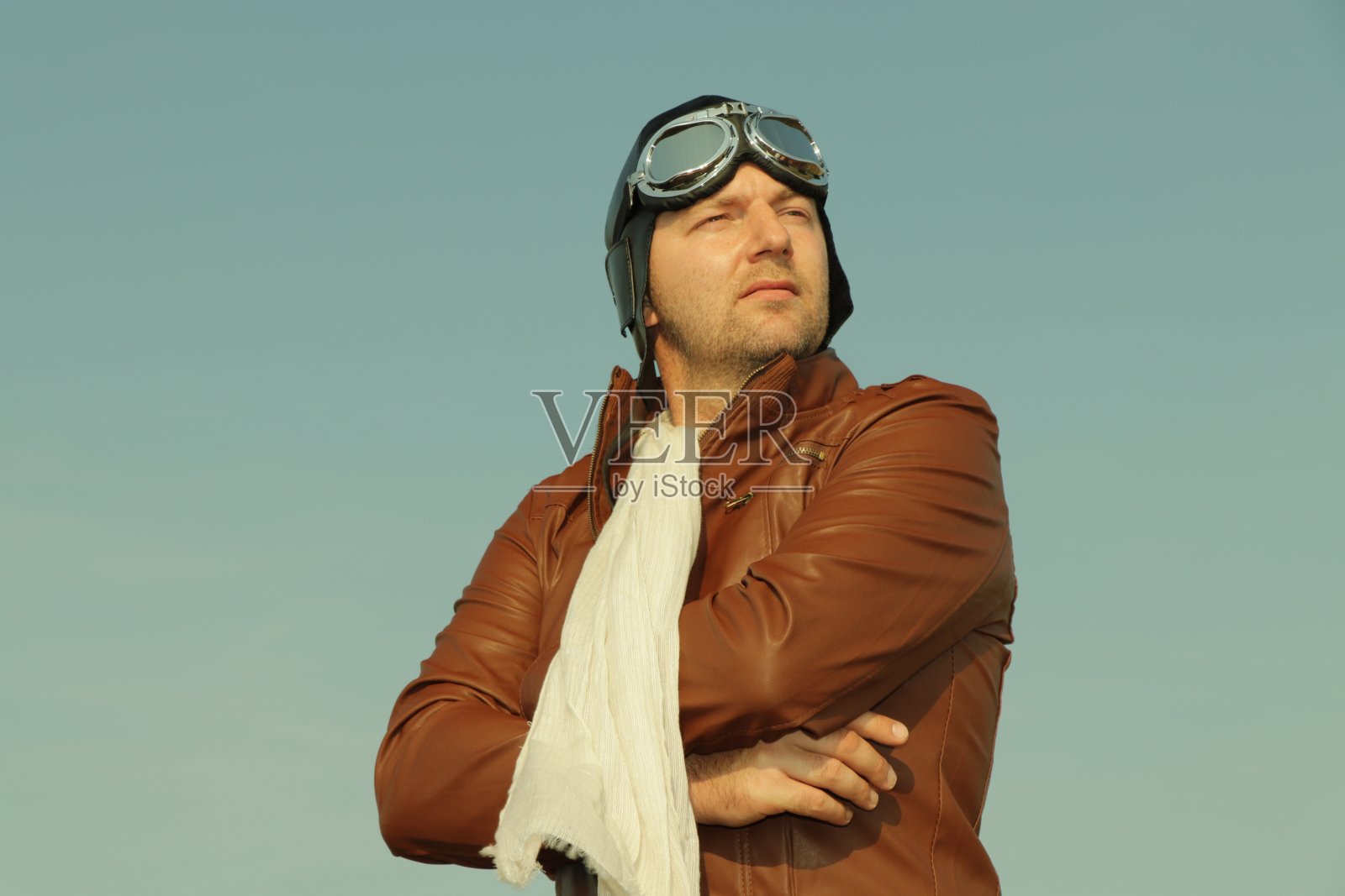 复古飞行员与皮革帽子,围巾和飞行员眼镜-肖像的一个人在历史飞行员服装照片摄影图片