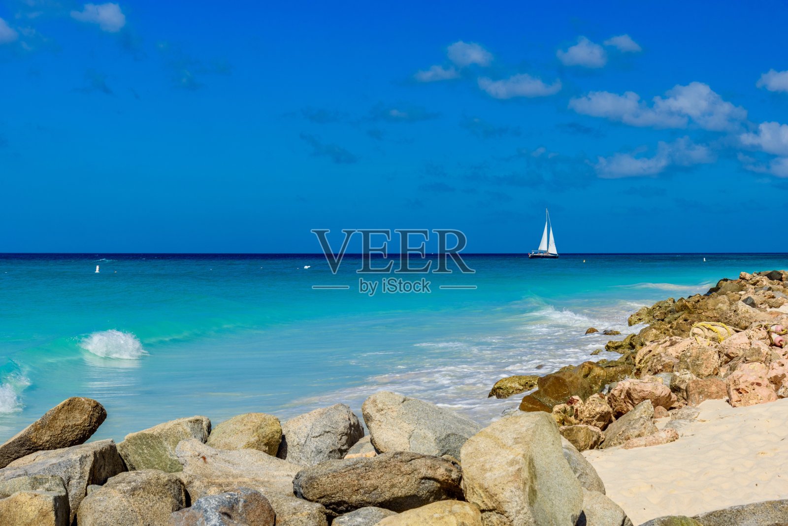 阿鲁巴梦幻般的鹰滩,背景是岩石和一艘船。照片摄影图片