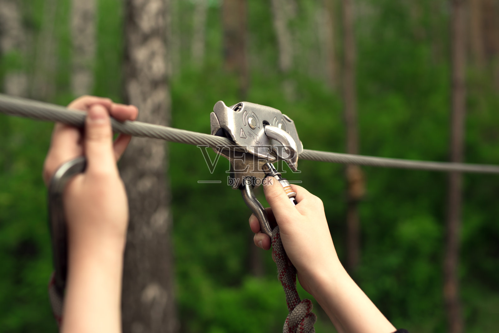双手握着滑索上的锁扣照片摄影图片