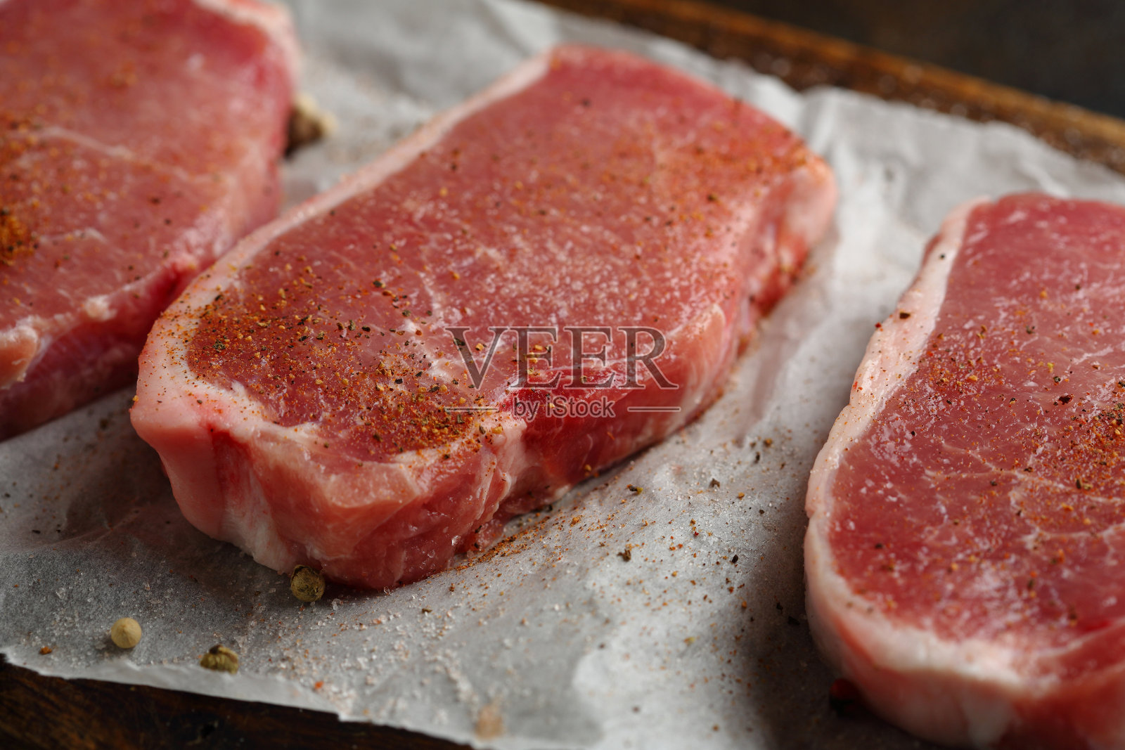 生肉用香料切成薄片放在木头上,食物特写照片摄影图片