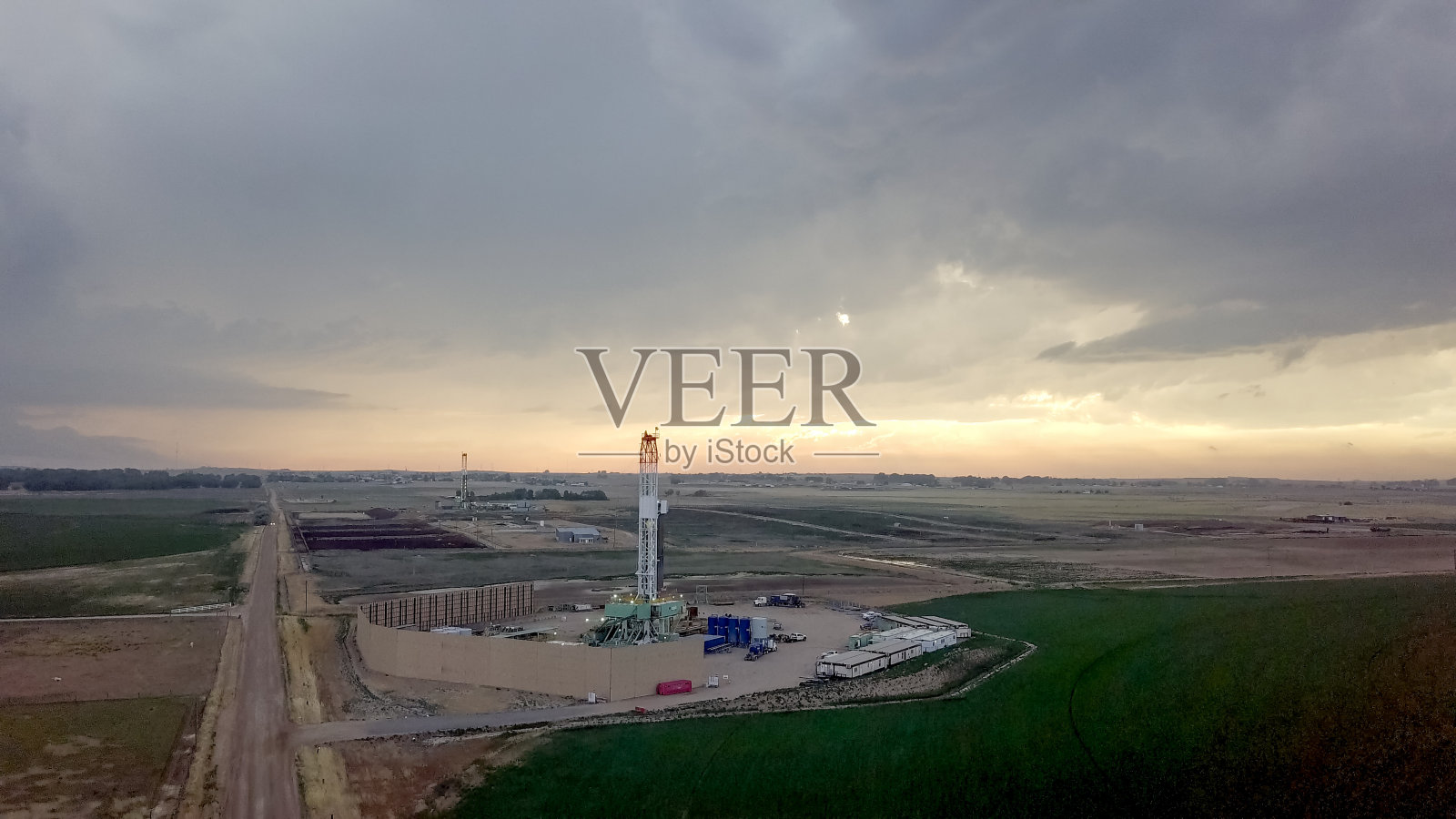 黄昏时分,戏剧性的天空前的水力压裂钻机照片摄影图片