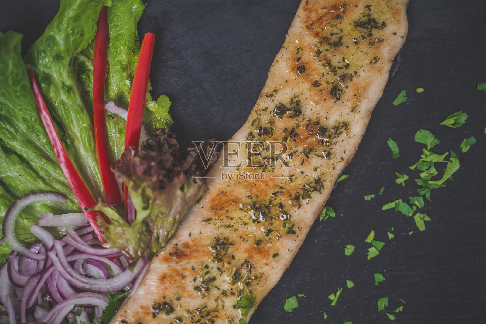 烤猪肉放在黑色的盘子里照片摄影图片