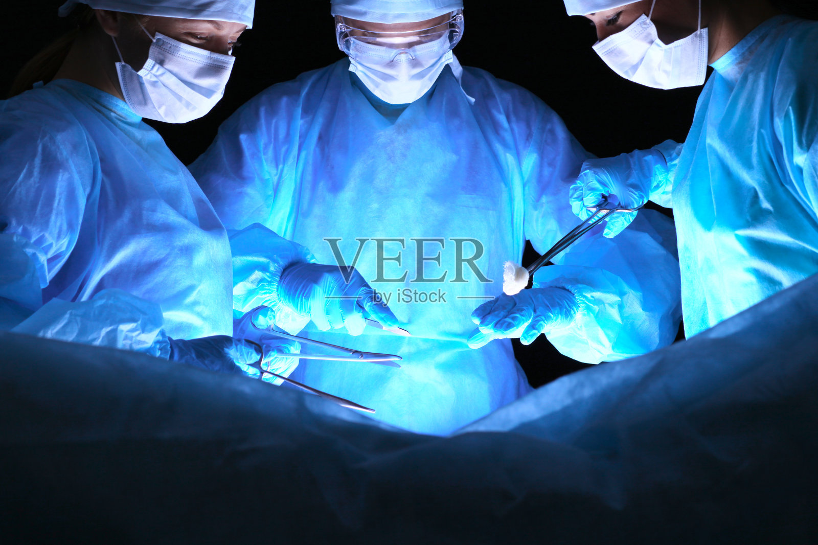 一群戴着口罩做手术的外科医生。医学、外科和急救概念照片摄影图片