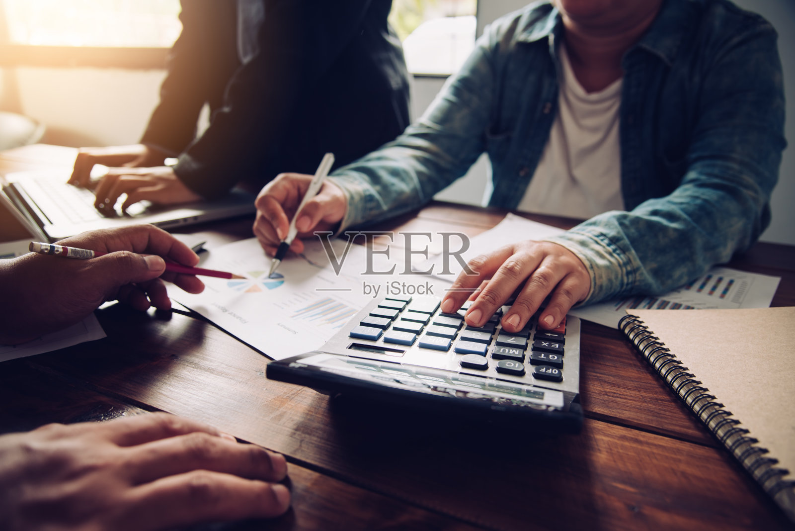 商务团队使用笔记本电脑和计算器在开放空间的办公室工作。正在进行会议报告照片摄影图片