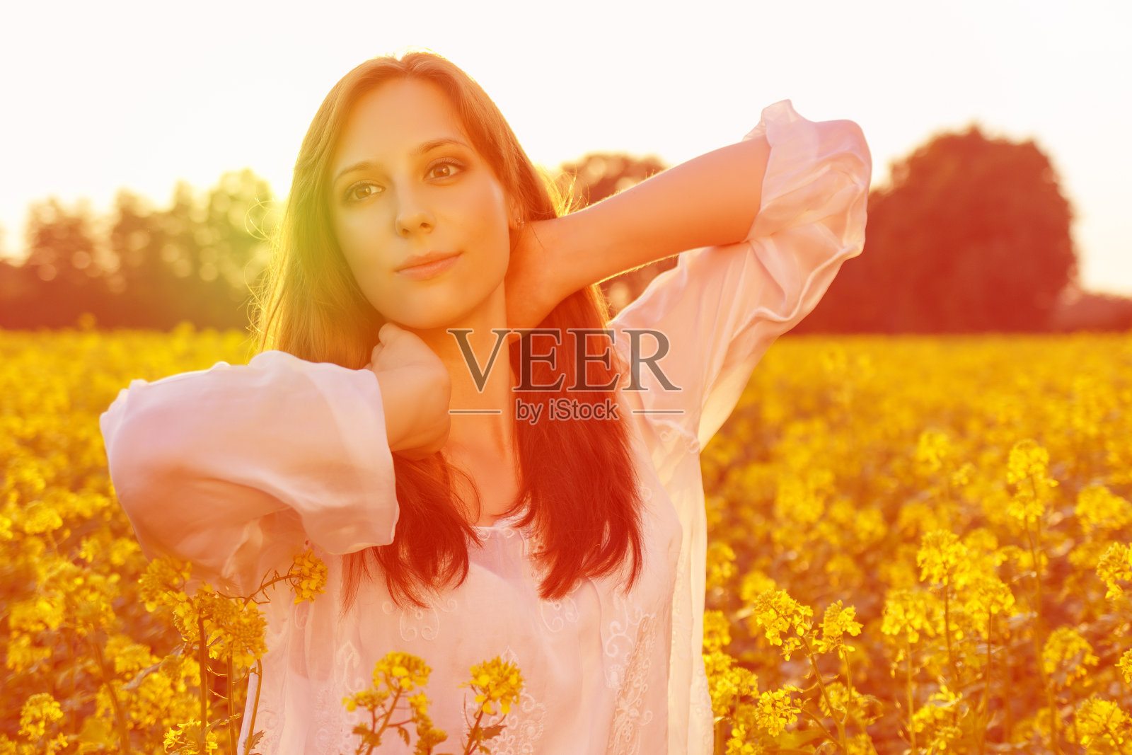 年轻的白人妇女在油菜花的领域摆姿势照片摄影图片