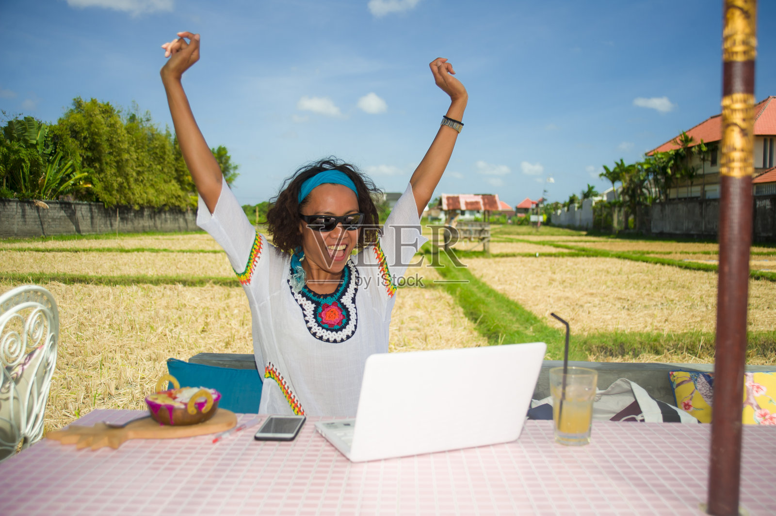 生活方式户外肖像年轻快乐和有吸引力的亚裔美国混合种族妇女工作与笔记本电脑和手机从美丽的咖啡馆在数字游牧的工作概念照片摄影图片