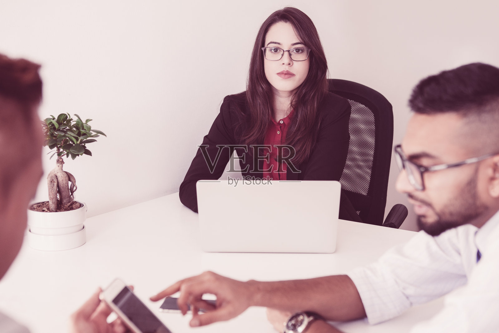 严肃的女性高管在开会时拿着笔记本电脑照片摄影图片