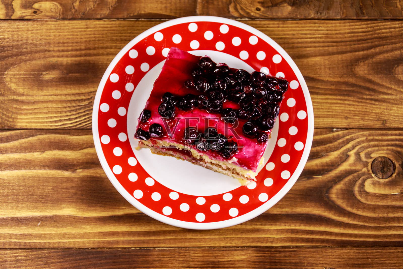 美味的芝士蛋糕配黑醋栗放在木桌上。俯视图照片摄影图片