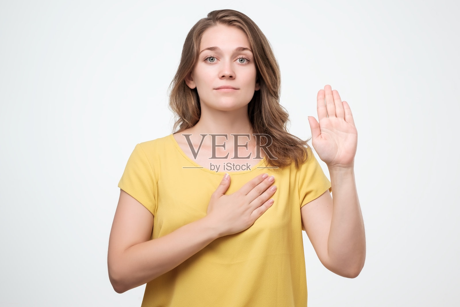 穿着黄衬衫的年轻白种女人正在承诺照片摄影图片