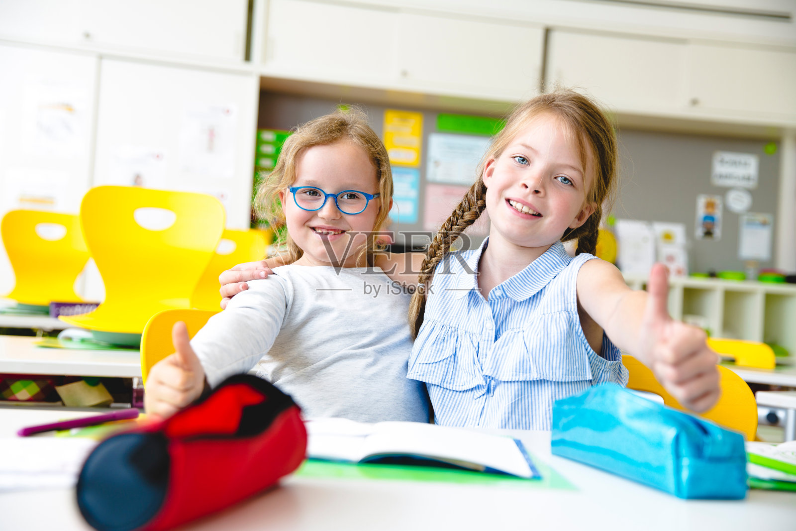 可爱的朋友在教室里学习时打手势的肖像照片摄影图片