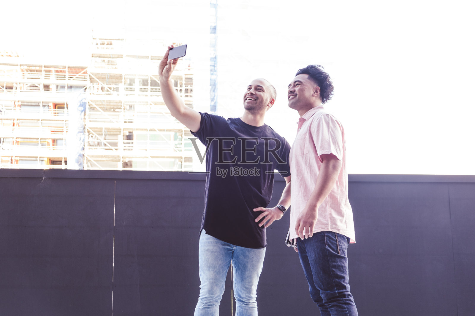 在新西兰奥克兰,快乐微笑的男性游客在户外用手机自拍照片摄影图片