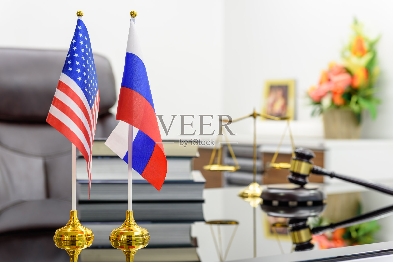美国和俄罗斯的国旗放在一张桌子上,还有书、木槌和正义的天平。华盛顿与莫斯科合作的象征,即军事对话、外交谈判。照片摄影图片