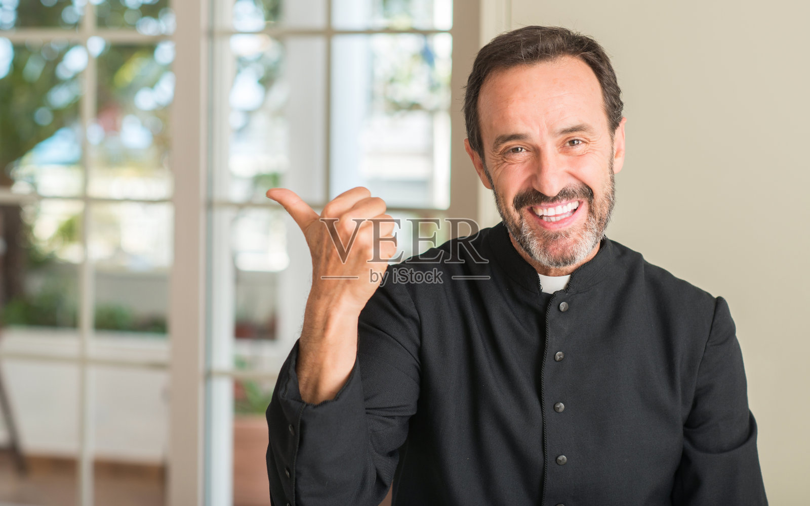 一名基督教牧师用手和手指向上指着笑脸照片摄影图片